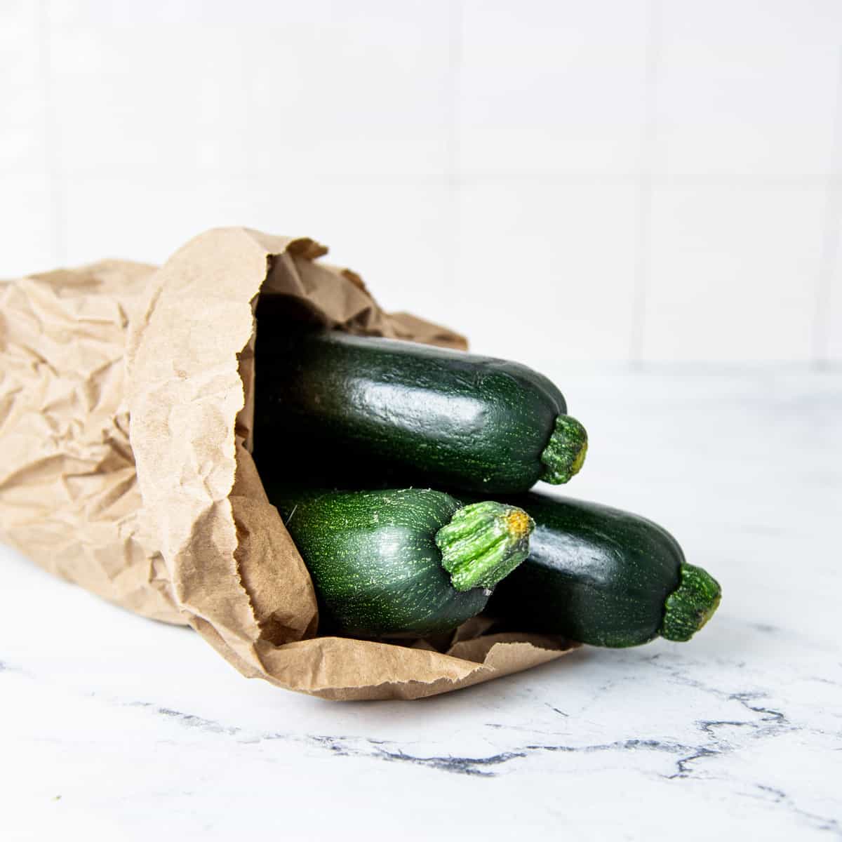 Zucchini in a bag on the counter.
